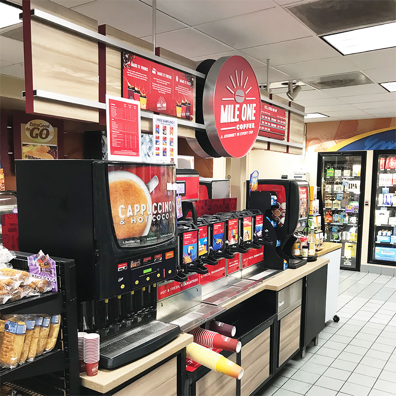 Convenience store coffee station with branded signage and organized beverage setup driving impulse purchases and customer flow