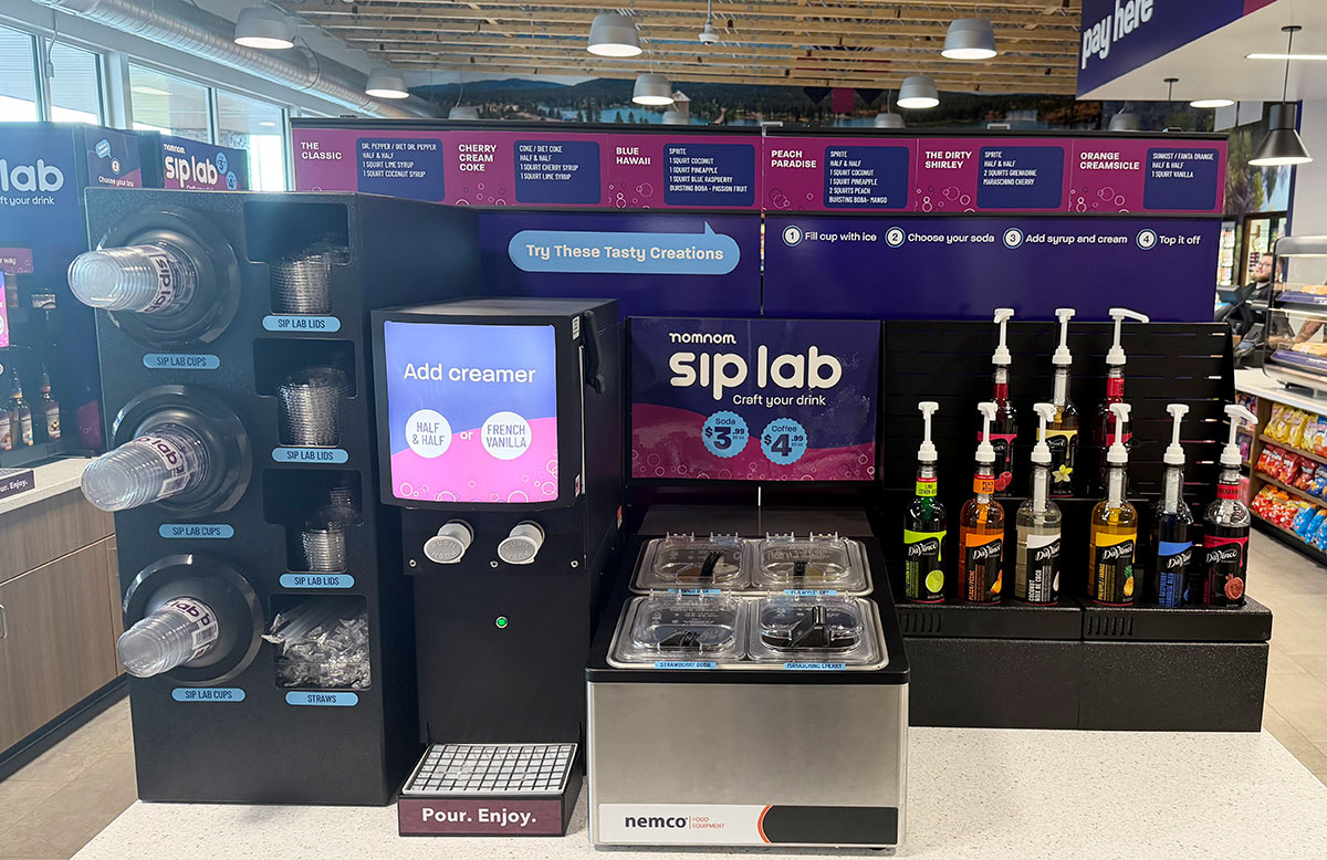 Dirty Soda display in a c-store featuring syrups, boba, creamer equipment shrouds, and cup dispensers and a background. 
